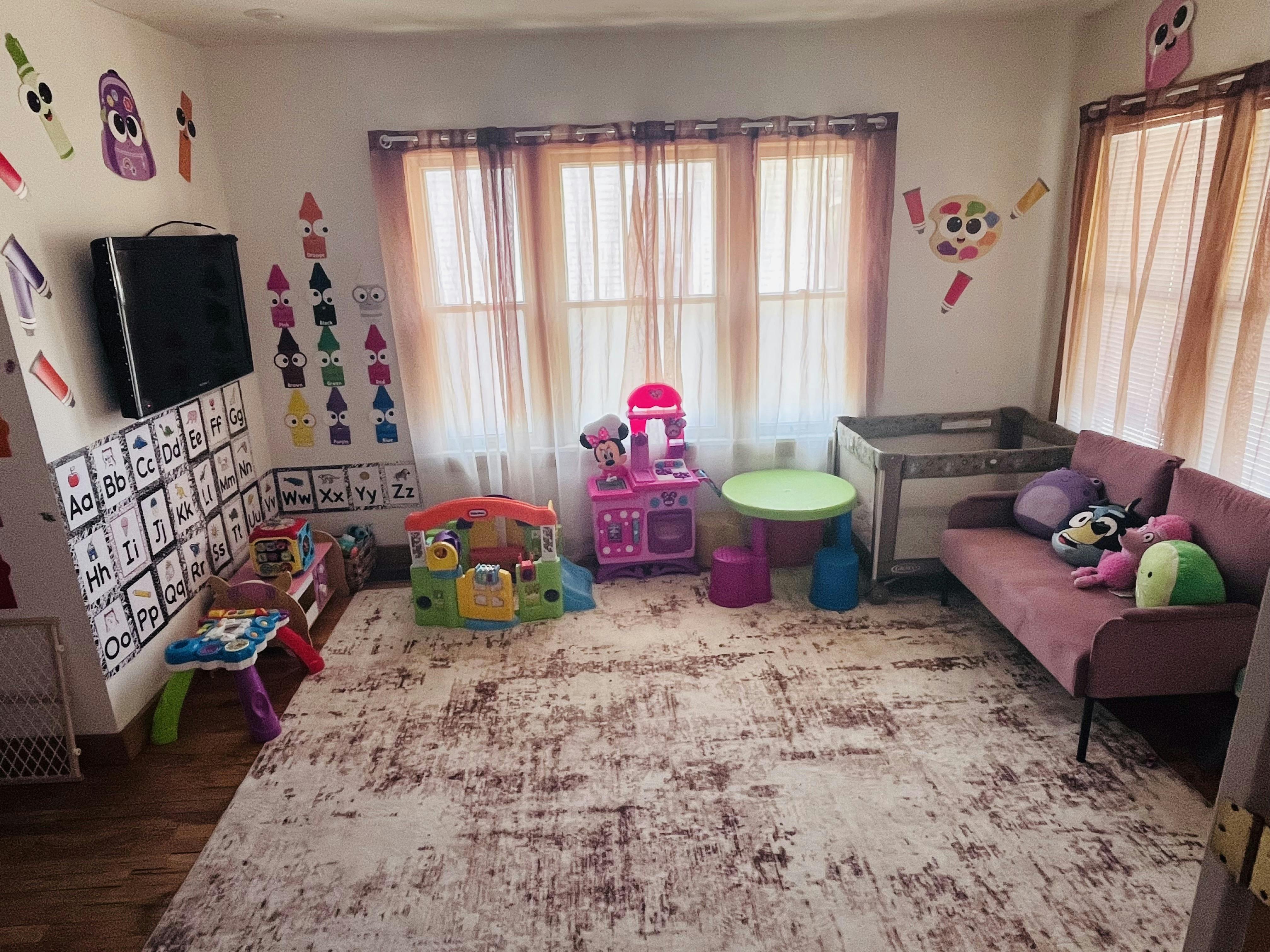 Playroom with alphabet charts, toy kitchen, and small furniture
