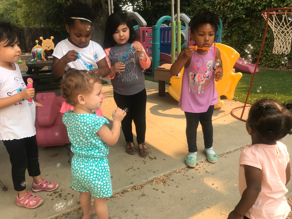 Children blowing bubbles outdoors
