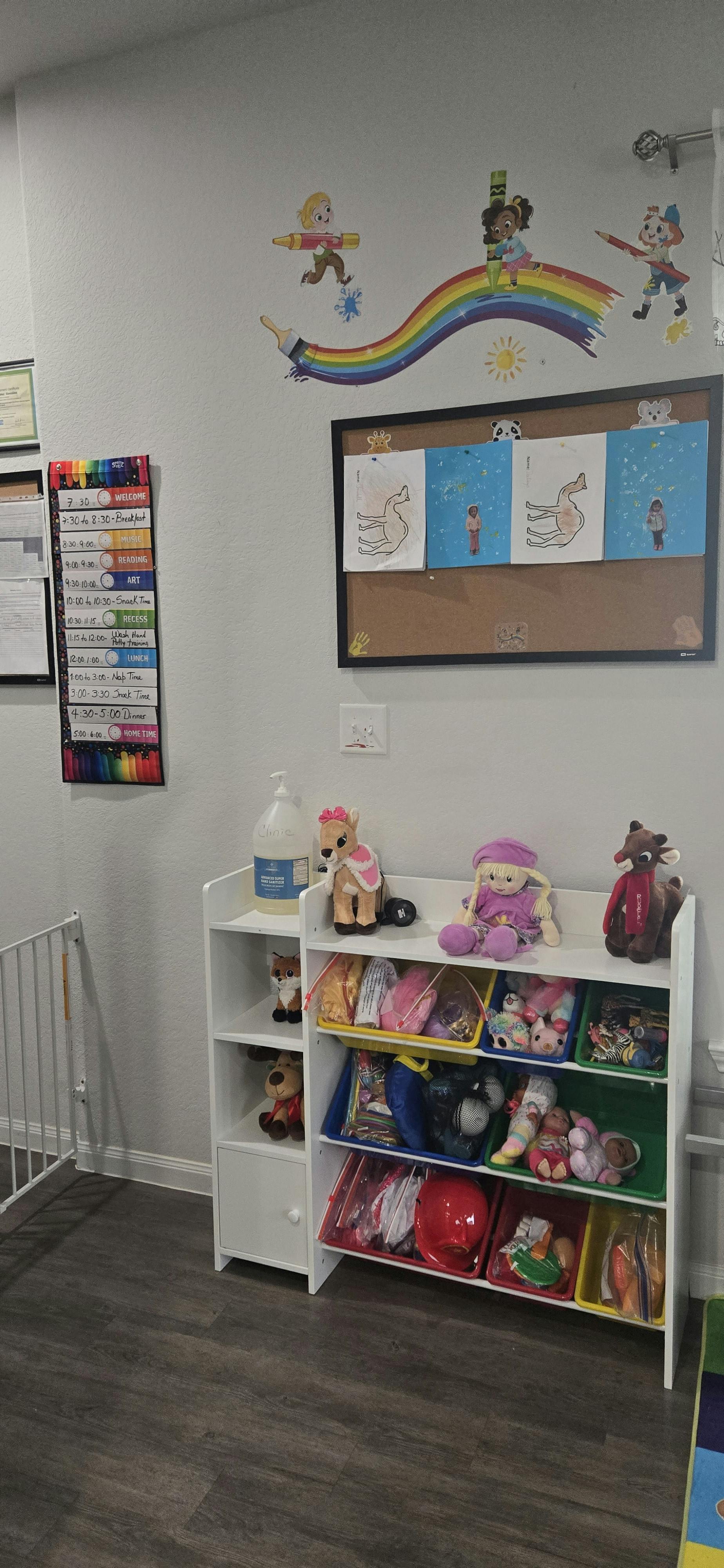Wall with children's drawings, rainbow decal, and toy storage unit