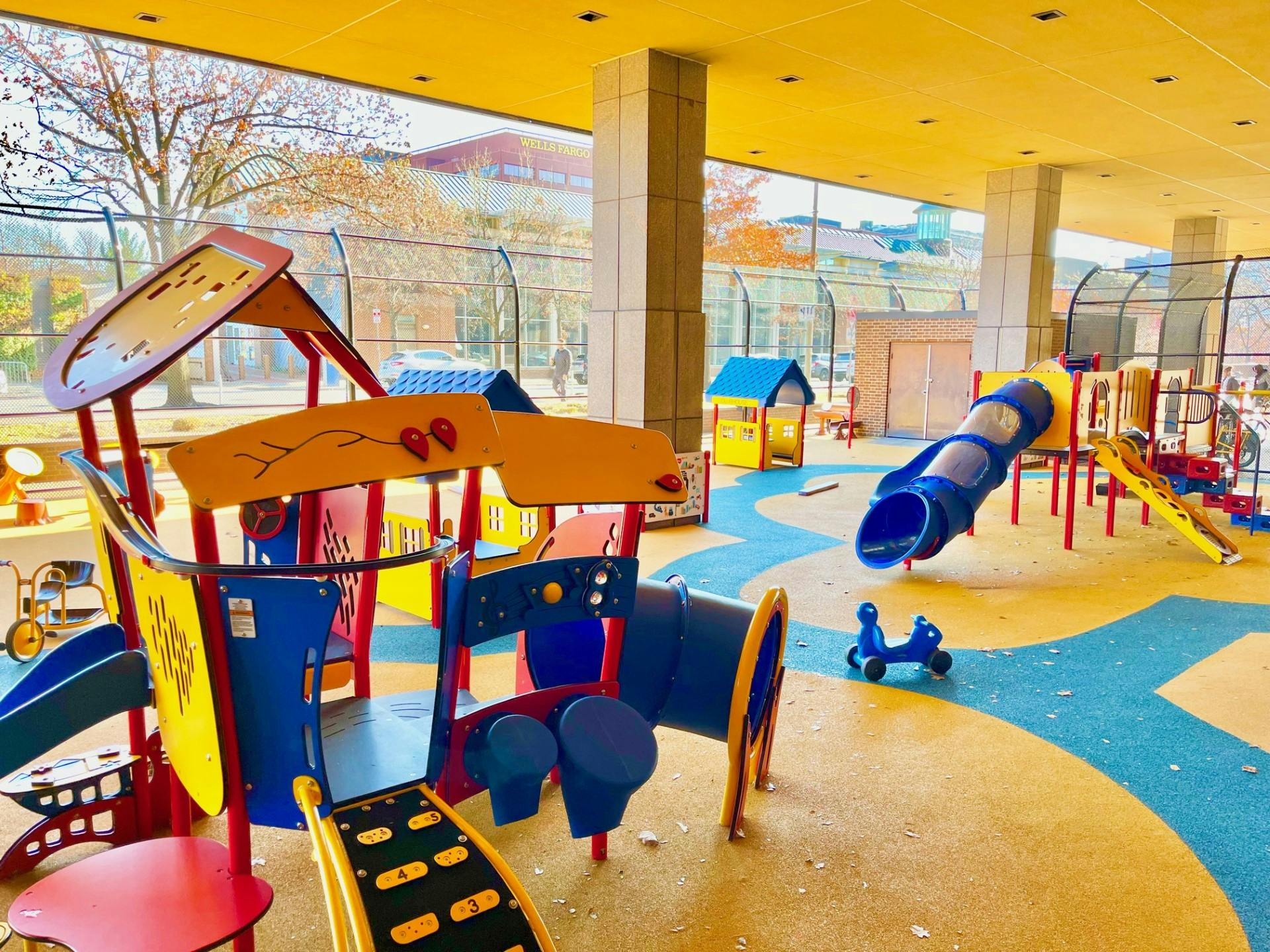 Colorful indoor playground with various slides and climbing structures