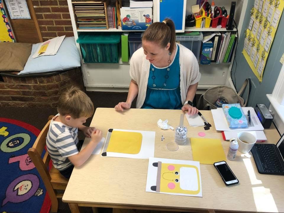 Person and child at a table with craft supplies