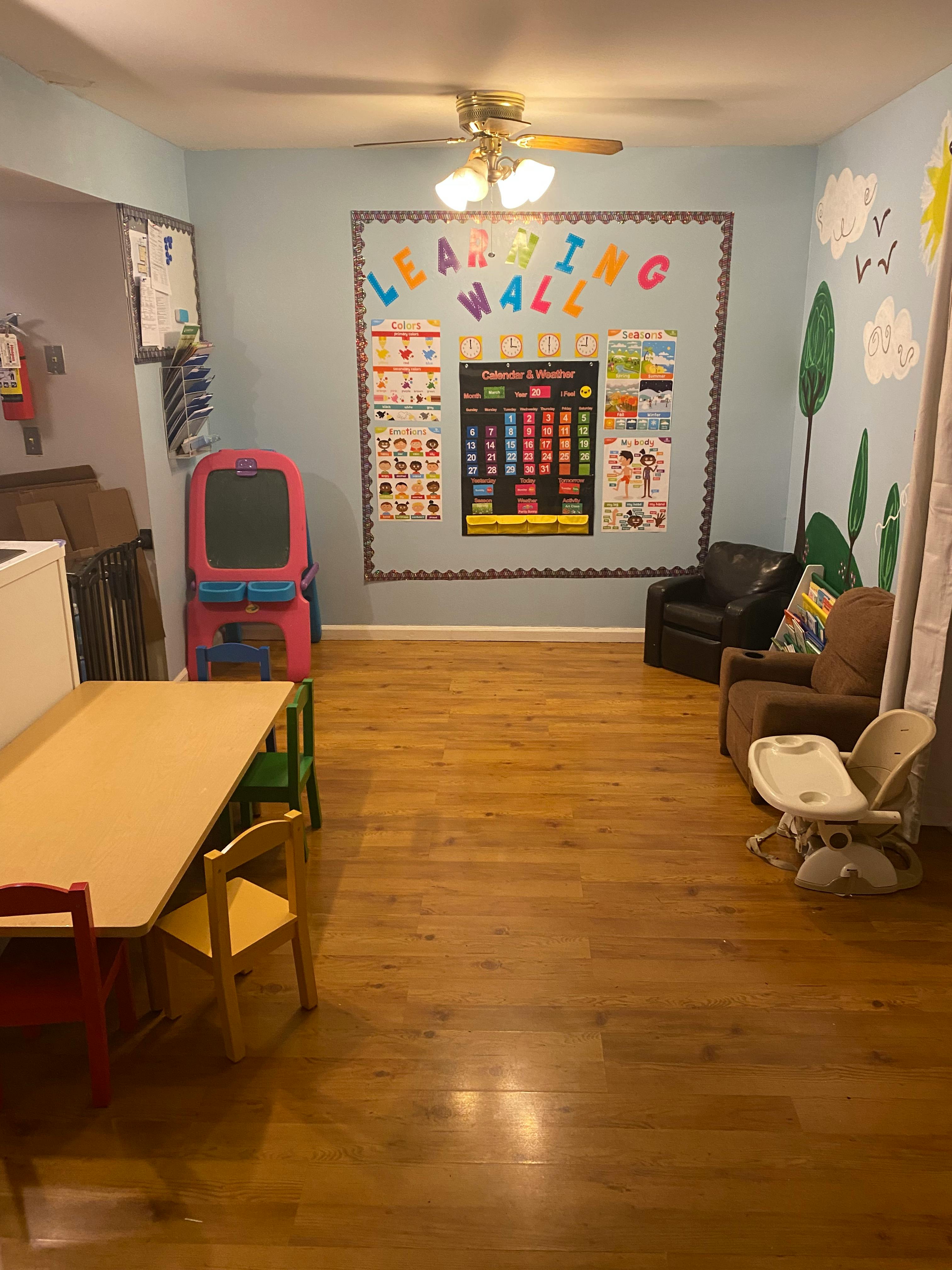 Classroom with a "Learning Wall" display, small tables, and chairs