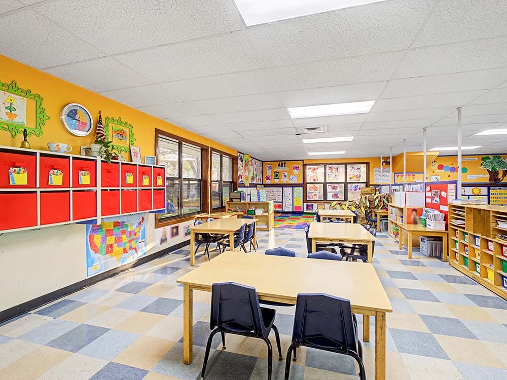 Empty colorful classroom with small tables and chairs