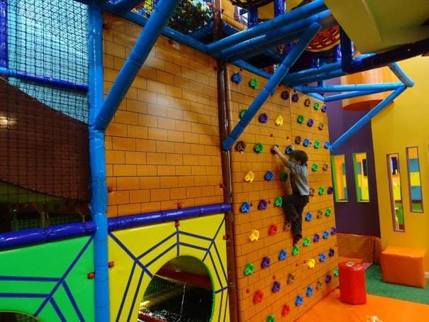 Child climbing a rock wall in an indoor playground
