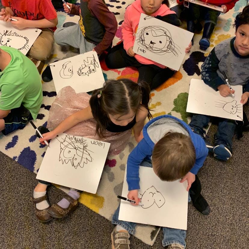 Children sitting on a rug drawing on paper