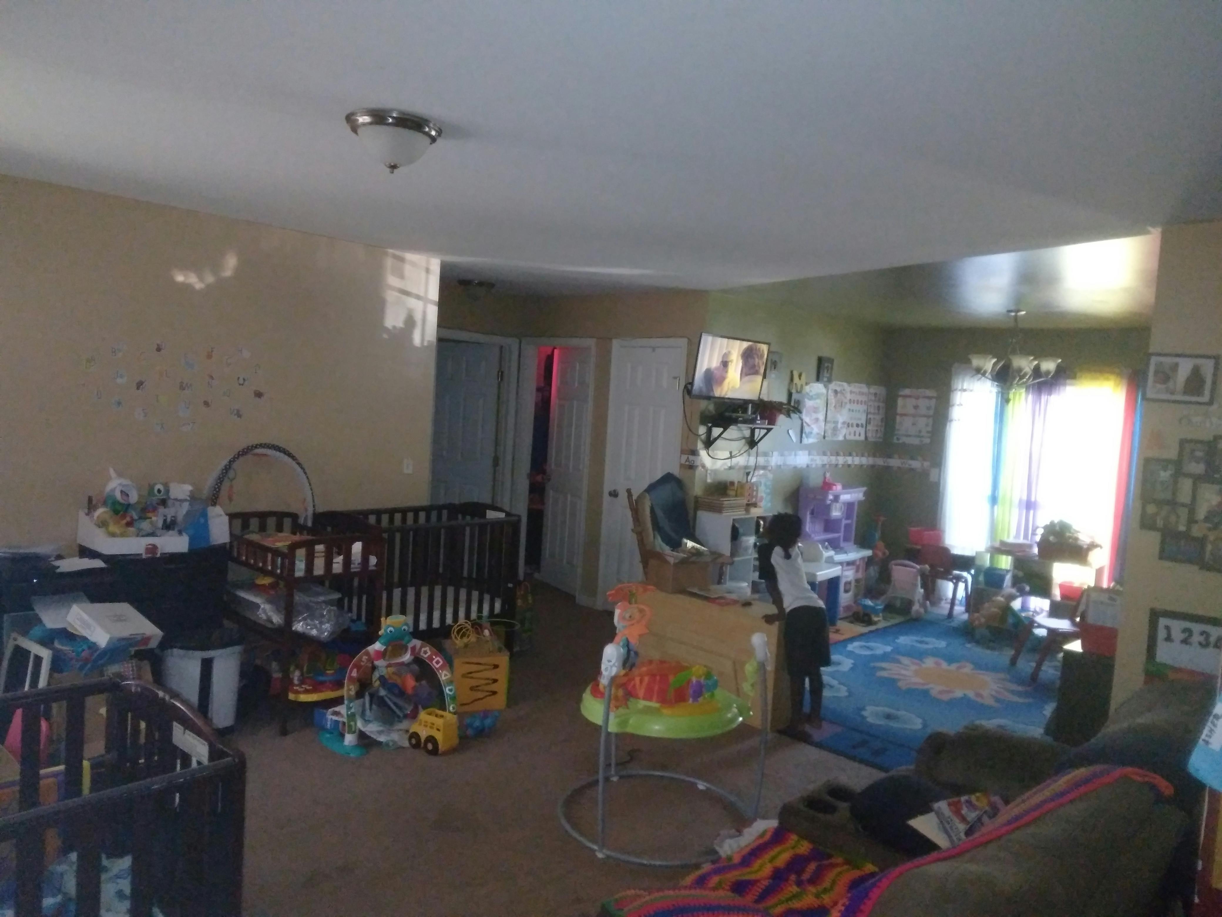 Room with two cribs and various child items