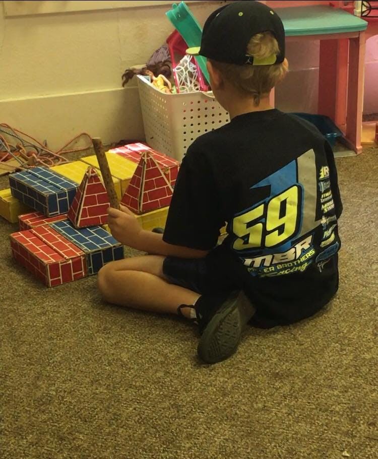 Child sitting on floor playing with building blocks