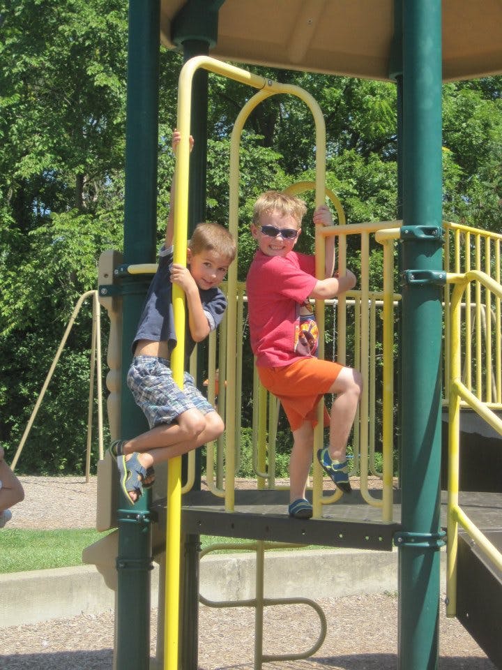 Two children playing on a playground structure