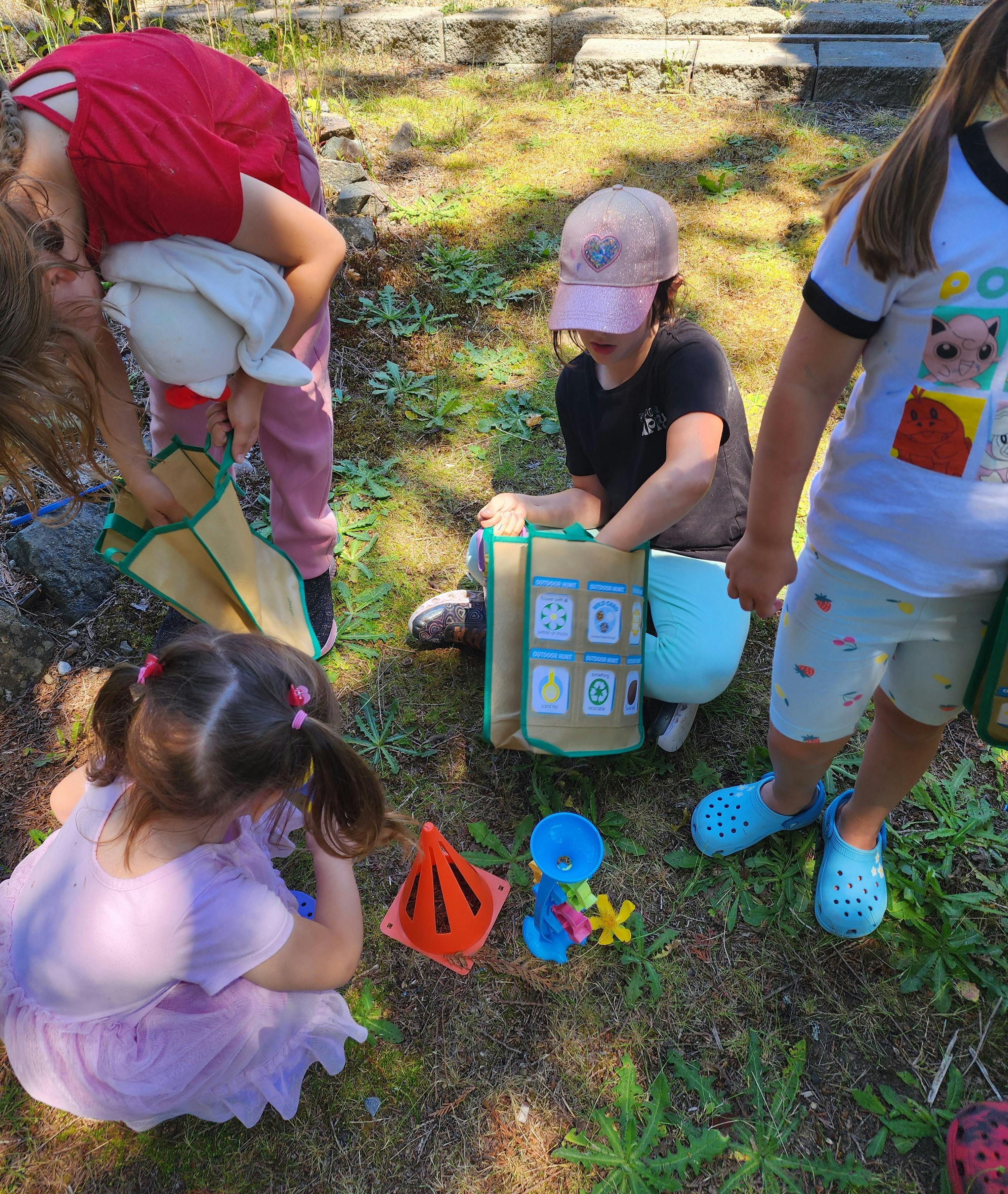 People and children playing outdoors with toys and bags