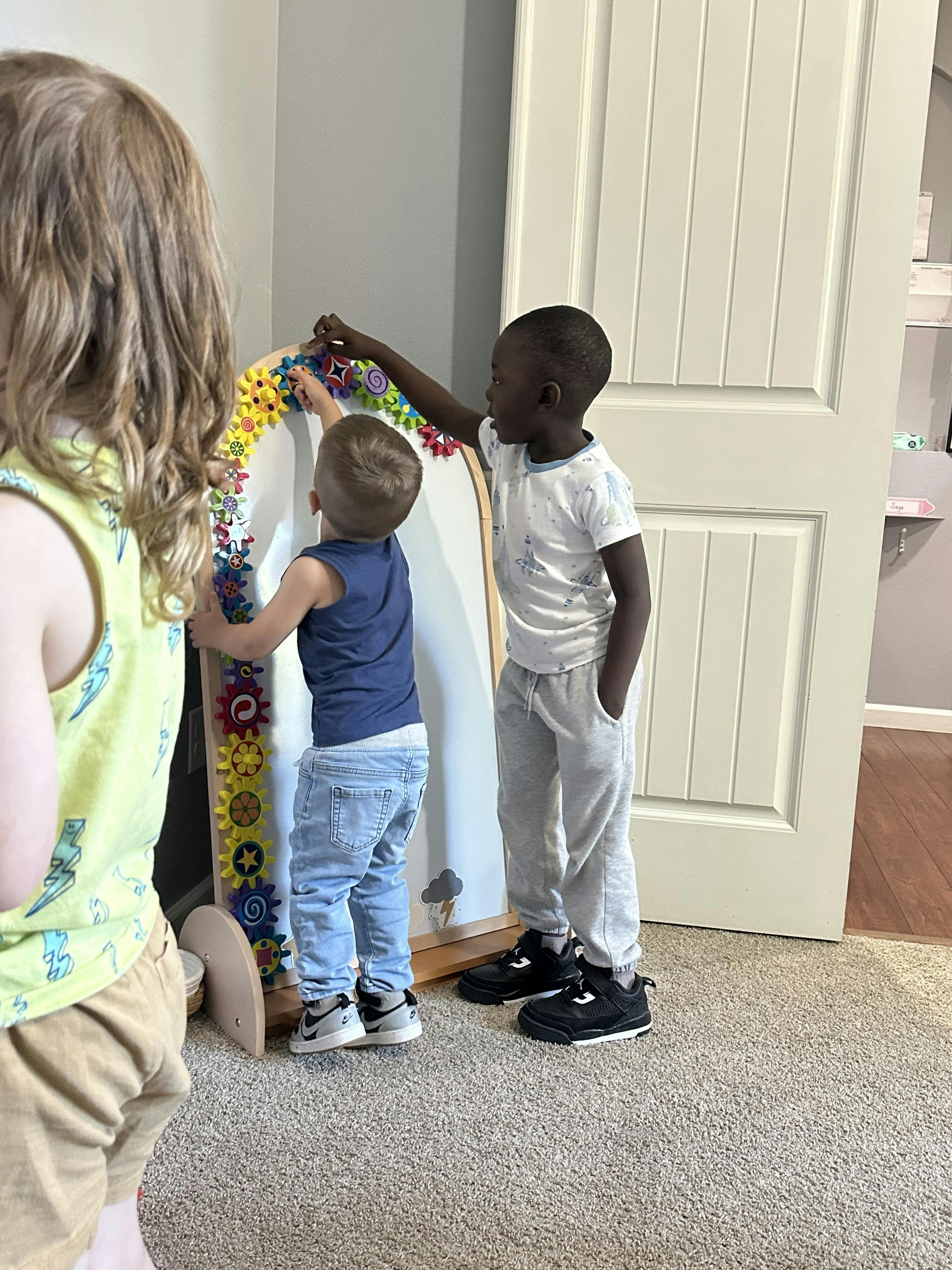 Children playing with a toy gear board
