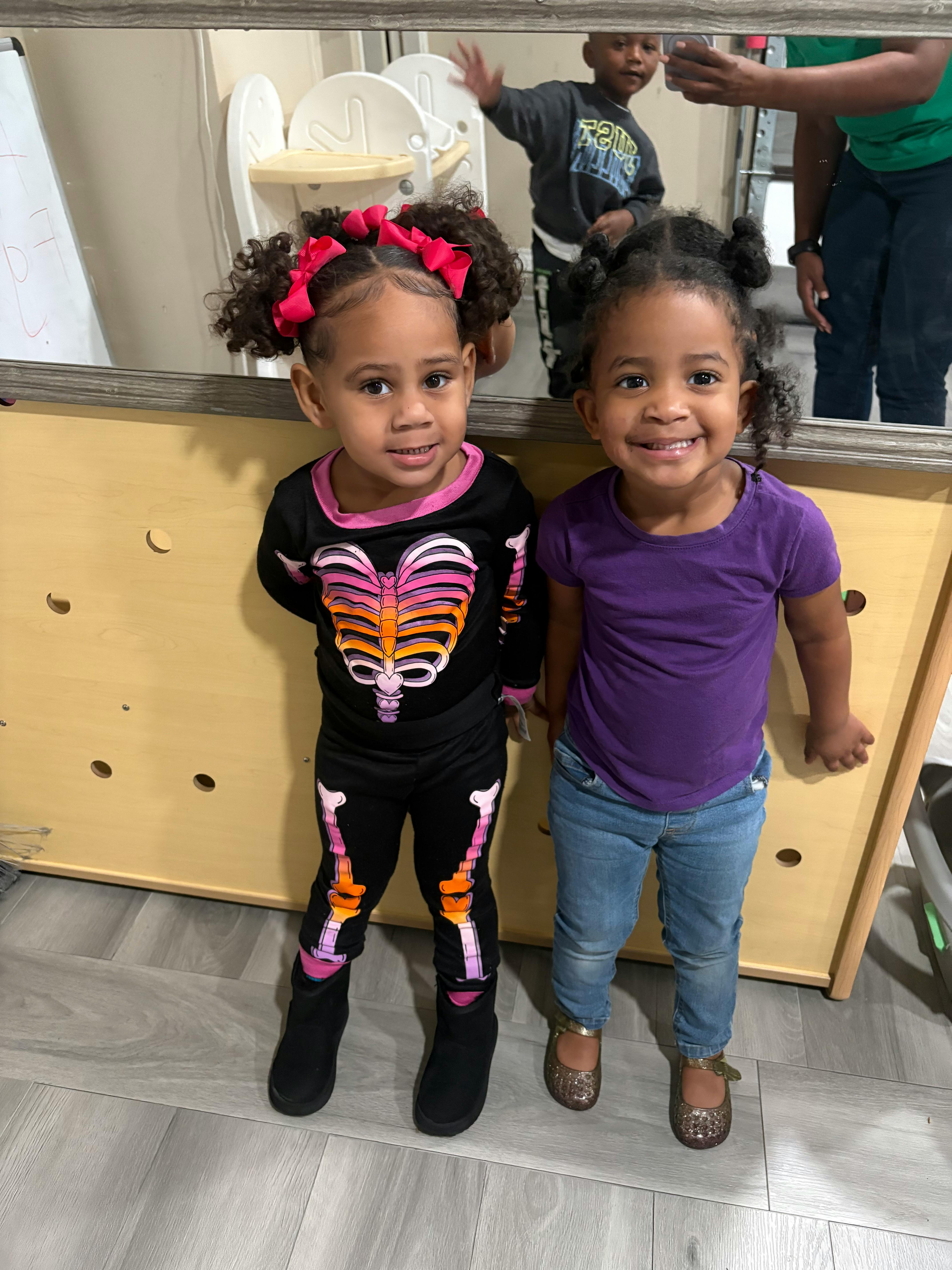 Two children standing in front of a mirror