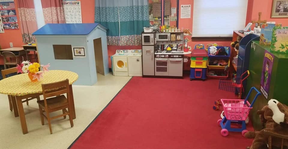 Playroom with toy house, kitchen, table, and shopping cart