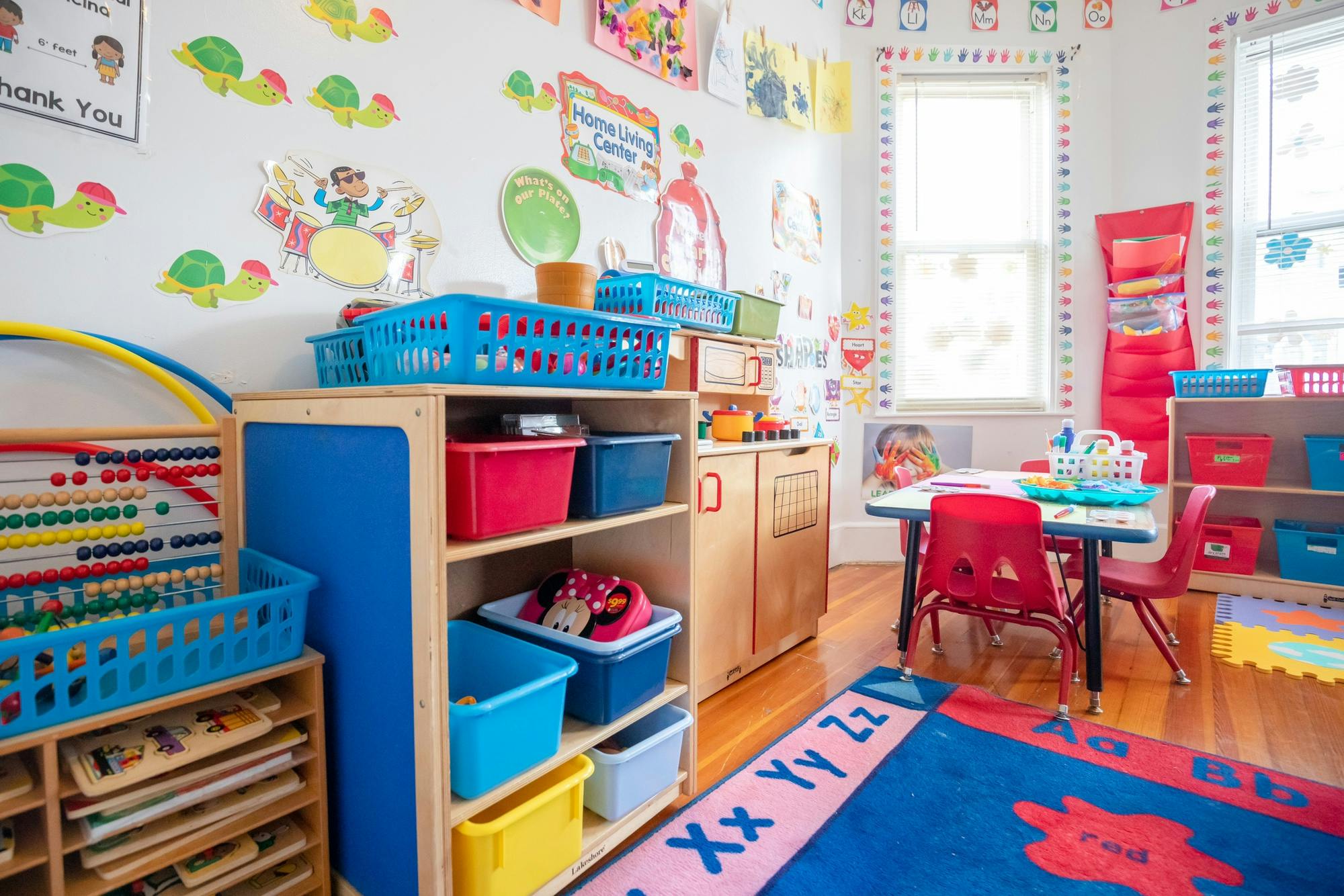 Colorful and organized classroom with shelves of toys, small tables, and wall decorations