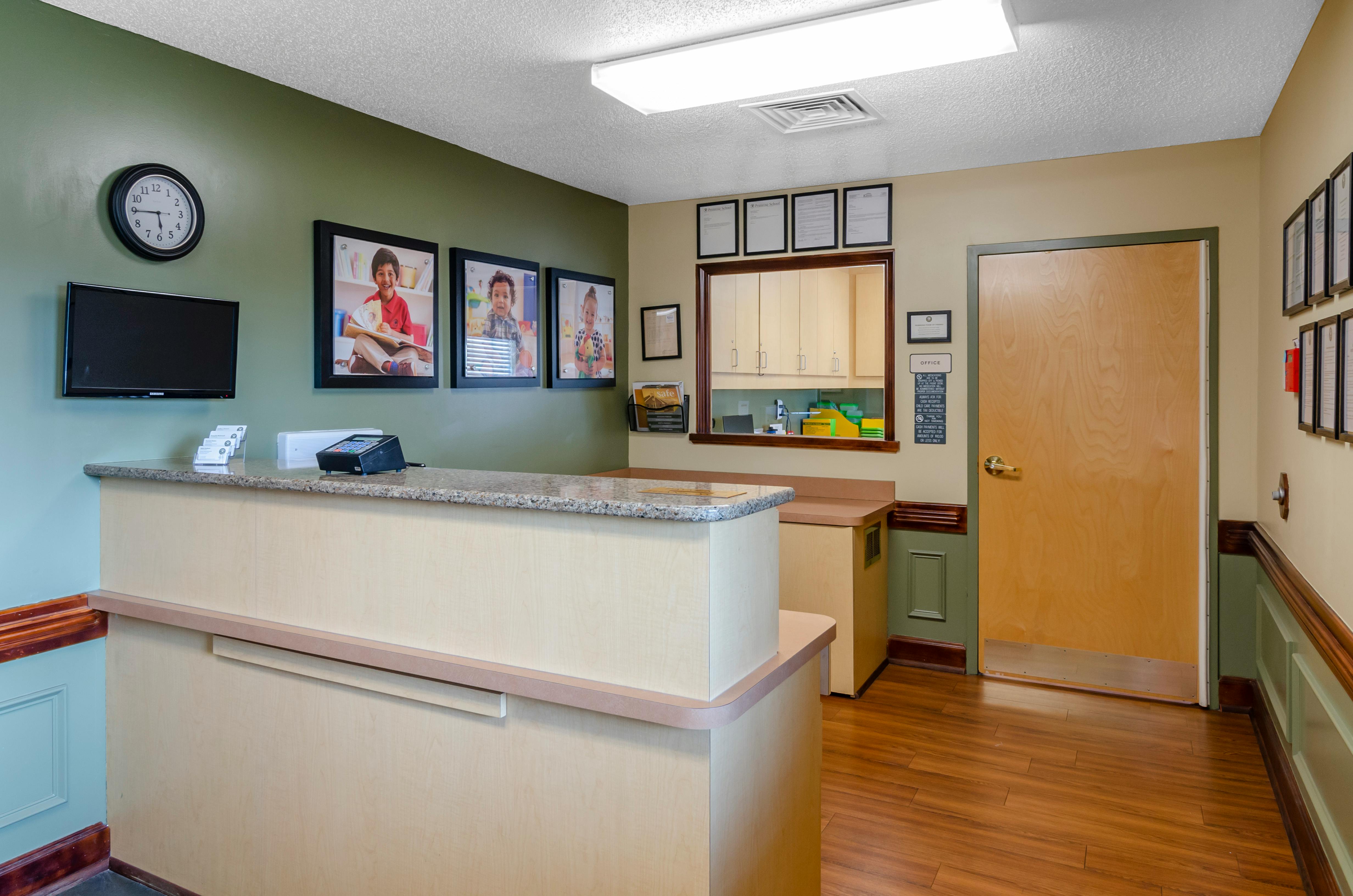 Reception desk in a waiting area with photos of children on the wall