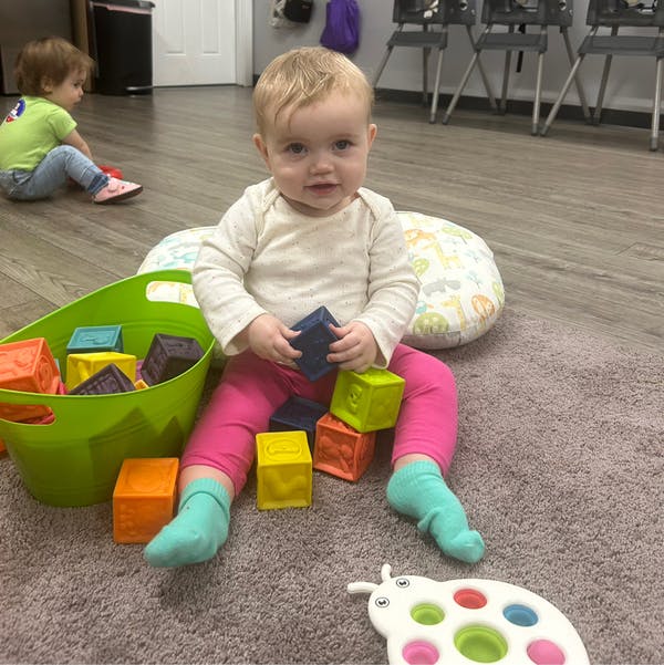 Child sitting on floor playing with colorful blocks