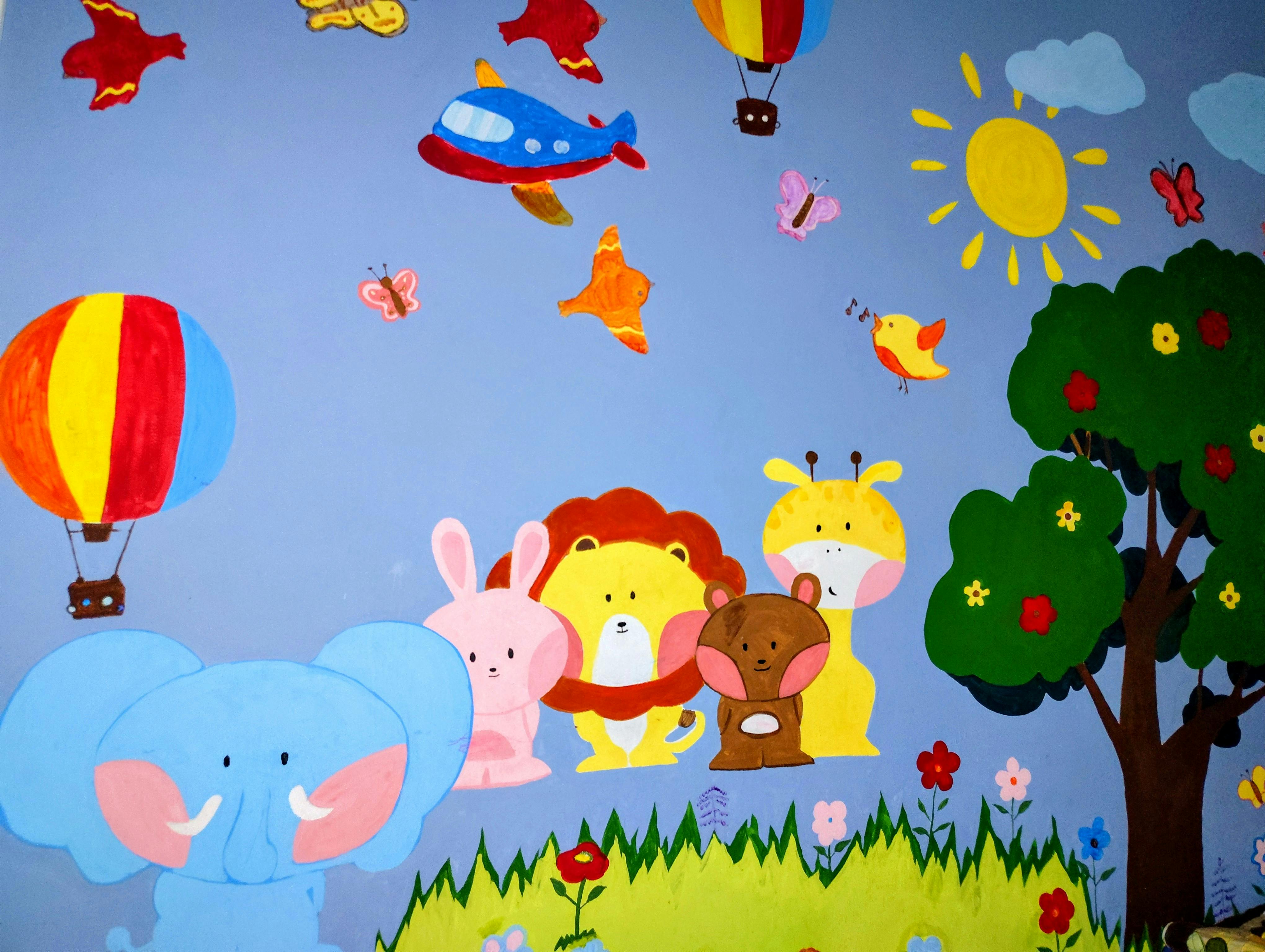 Colorful wall mural of cartoon animals including an elephant, lion, and giraffe