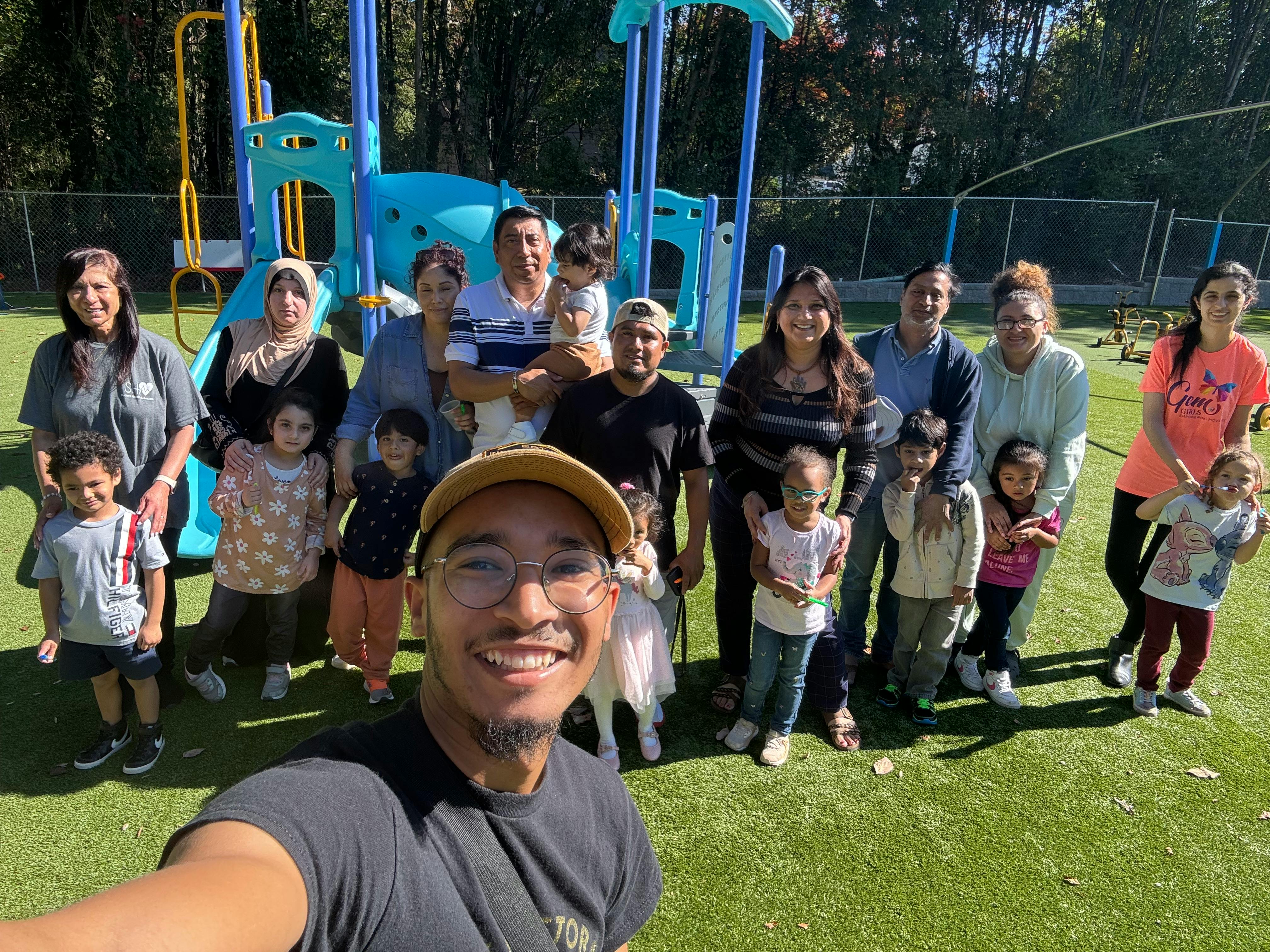 Group of adults and children posing for a photo on a playground