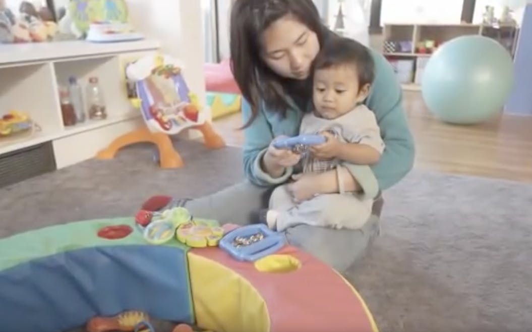 Person holding a toy for a child