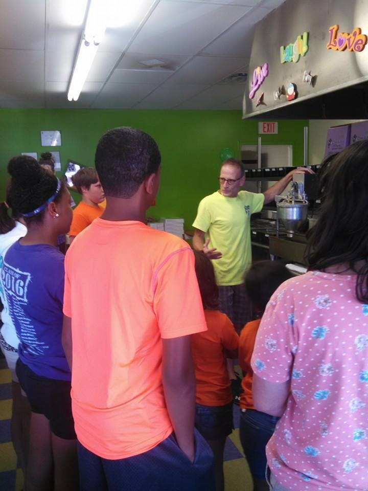 Adult person speaking to a group of children and teens