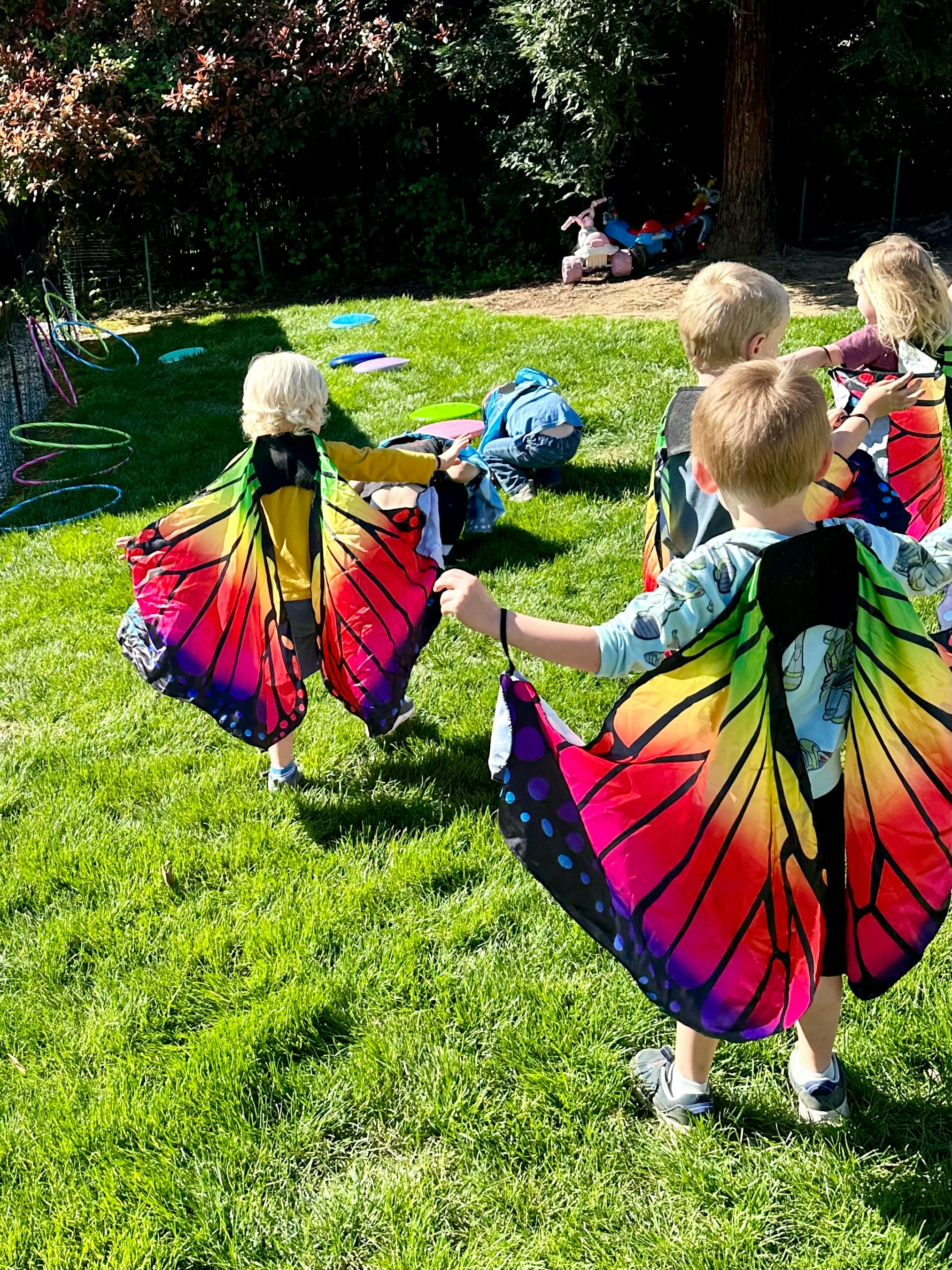 Children playing outdoors in butterfly wings