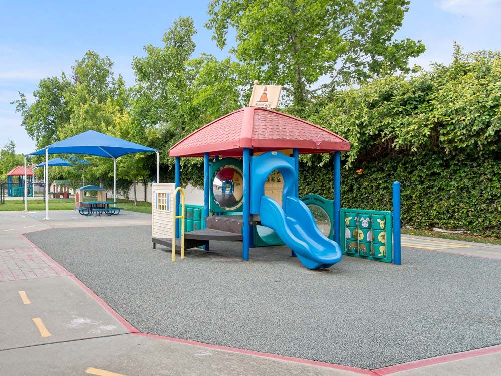 A children's playground with a blue slide and other play equipment