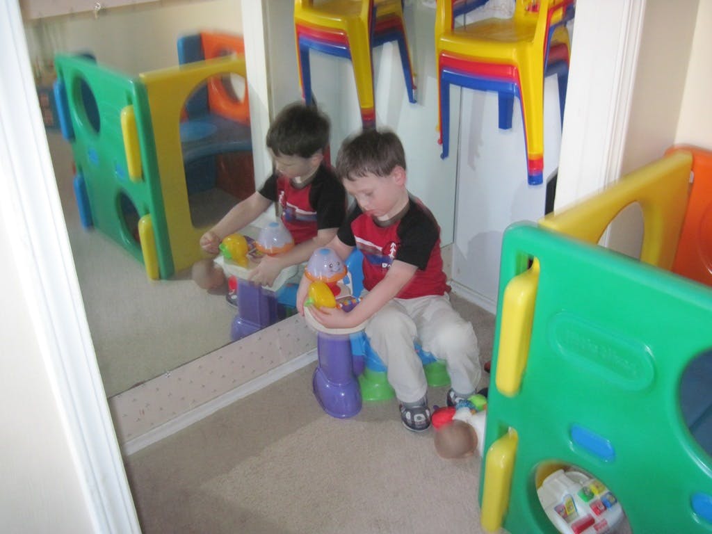 Child playing with a toy in front of a mirror