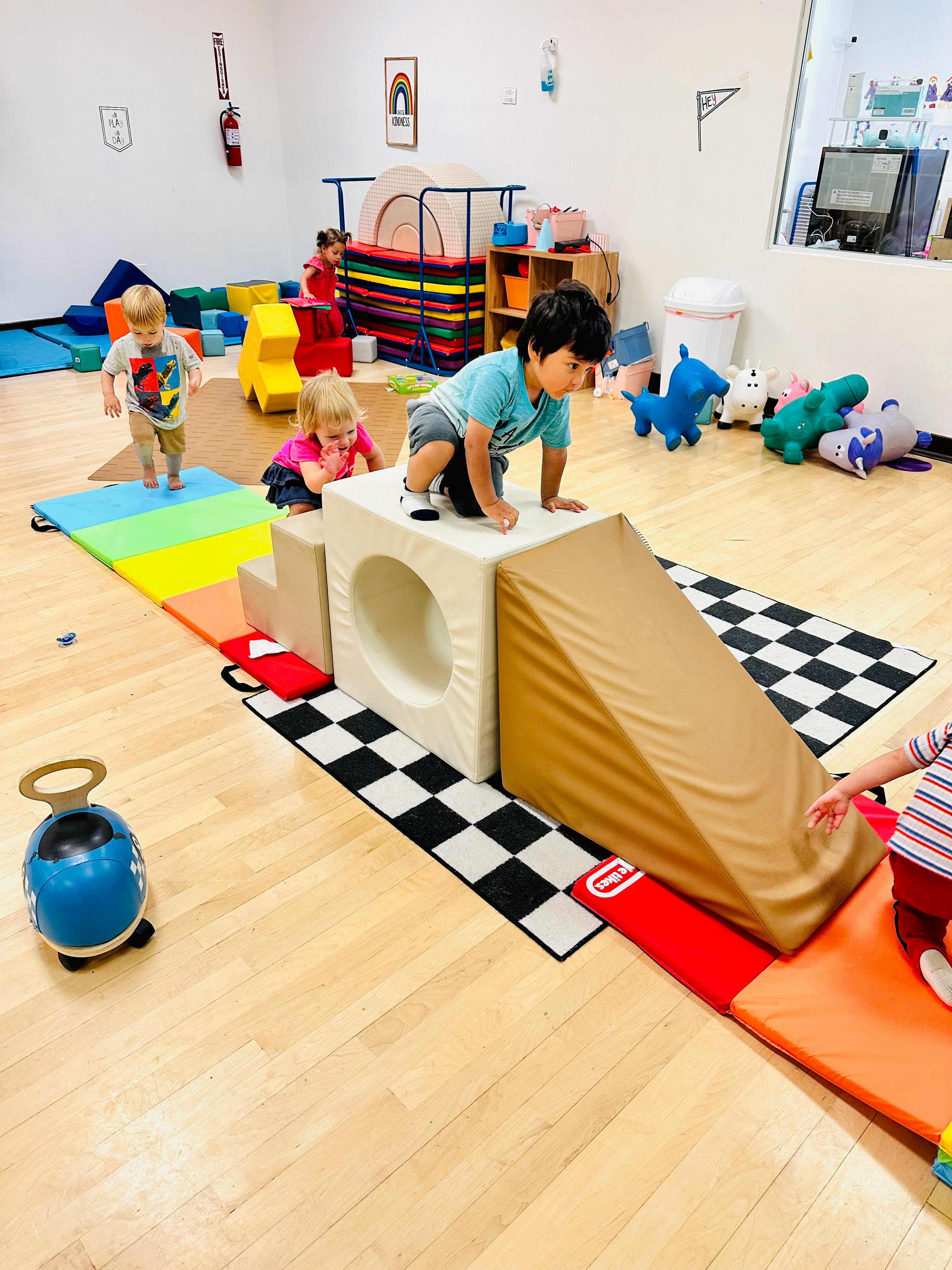 Children playing on soft play equipment in a room