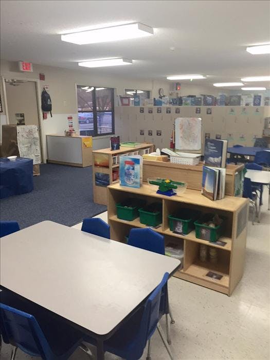 Classroom with tables, chairs, and shelves
