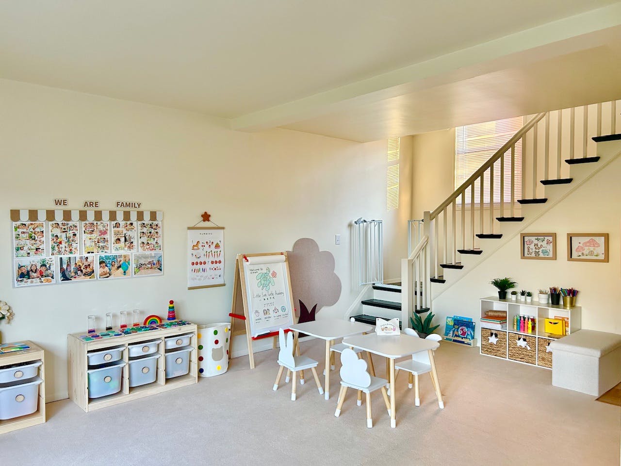 Playroom with small tables and chairs, storage units, and a staircase
