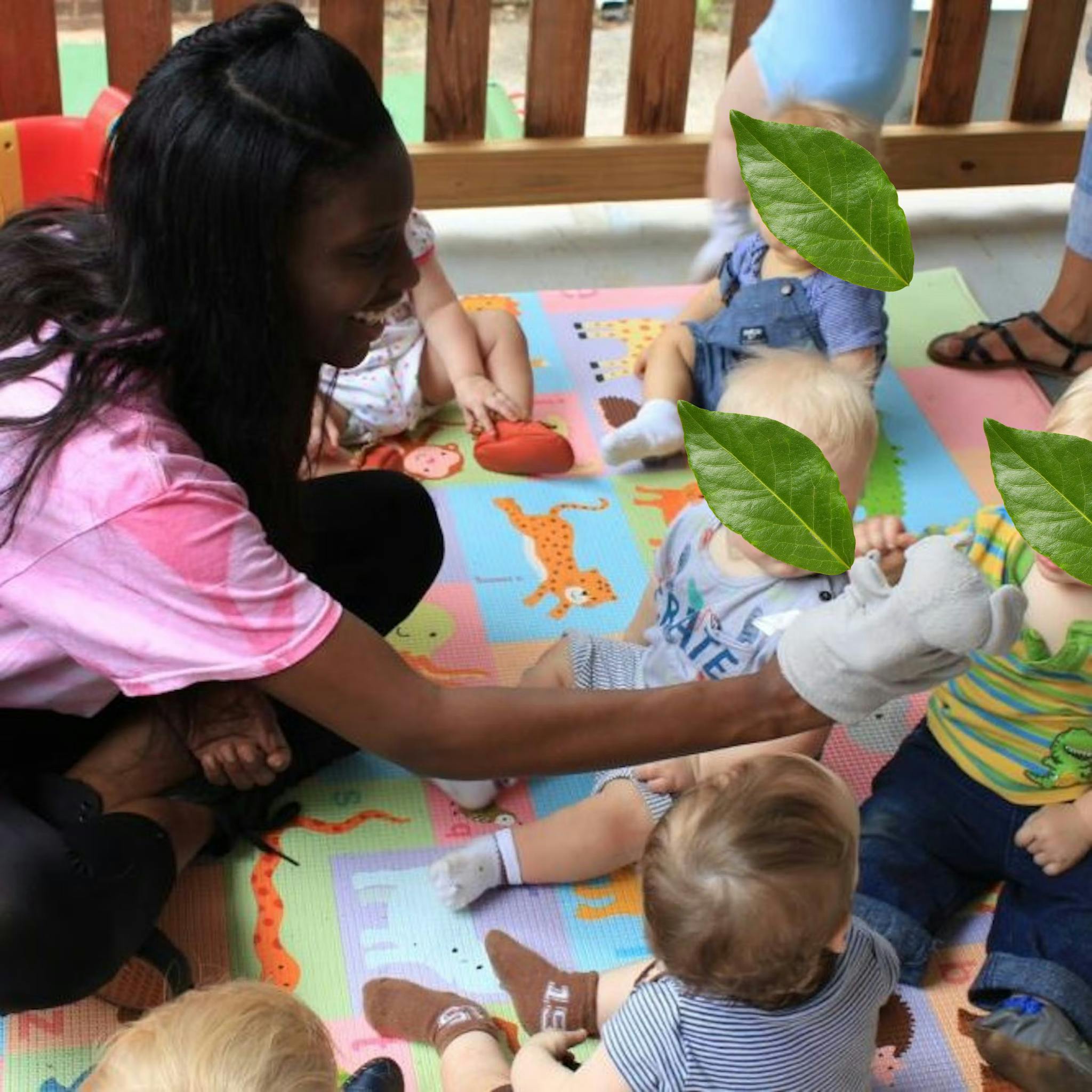 Person on floor playing with infants on a colorful mat