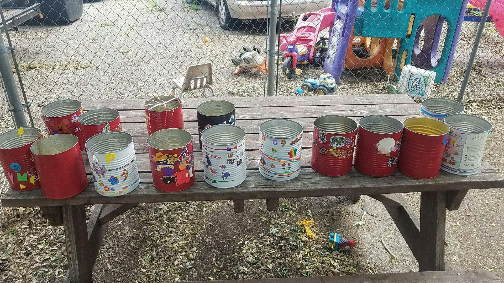 Painted tin cans on a wooden picnic table