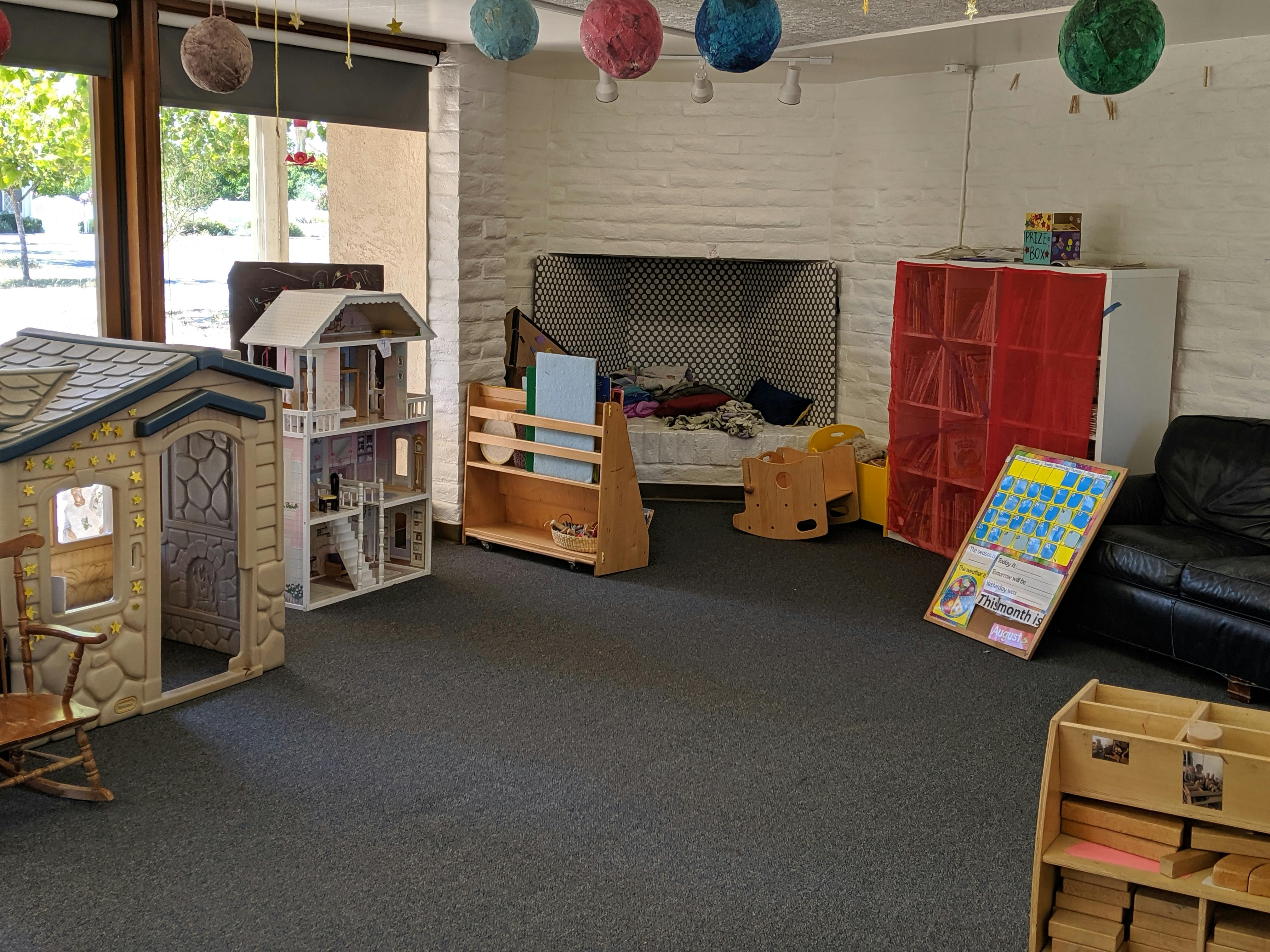 Playroom with a playhouse, dollhouse, and various toys