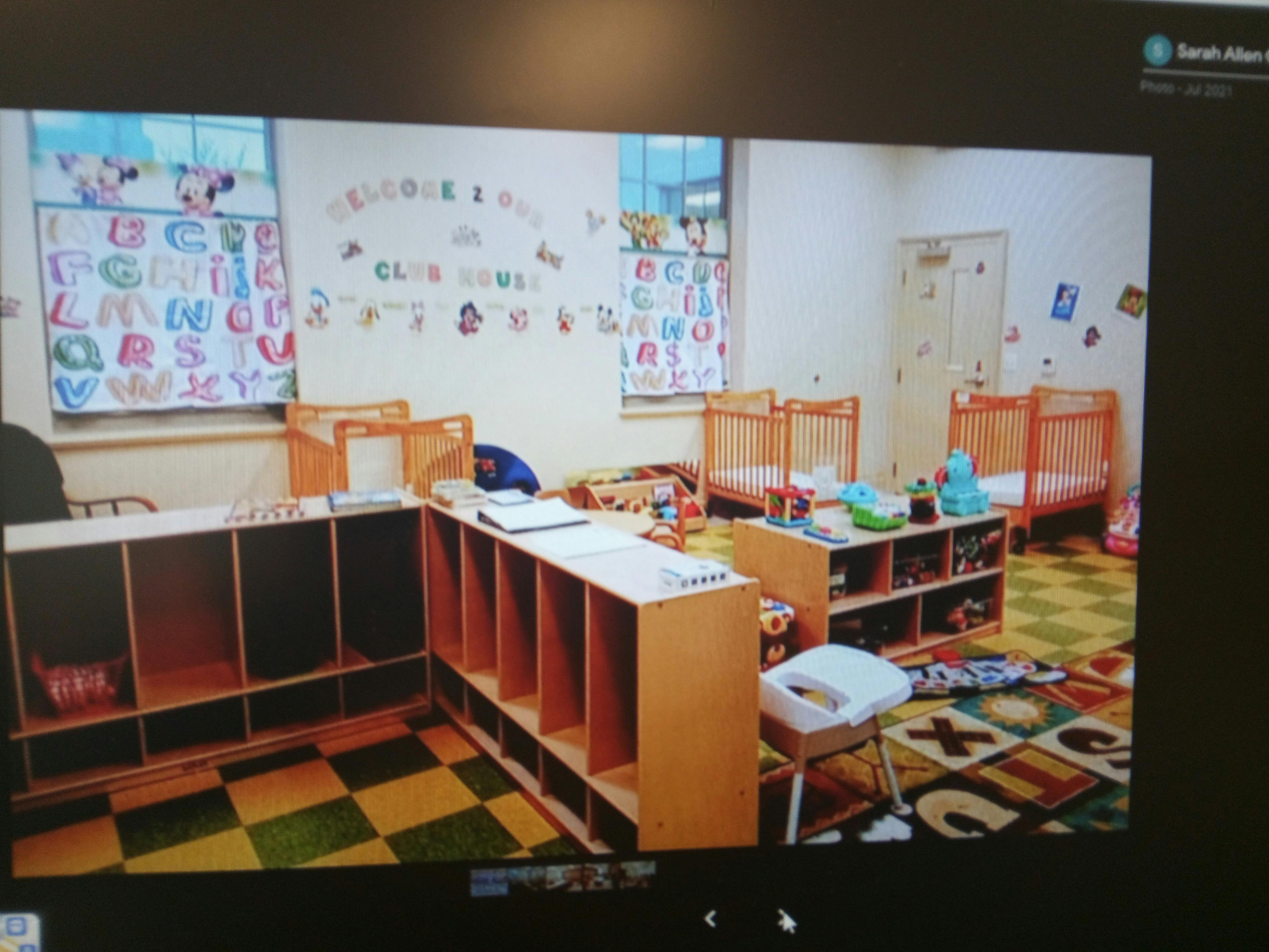 Empty classroom with cribs, shelves, and alphabet charts