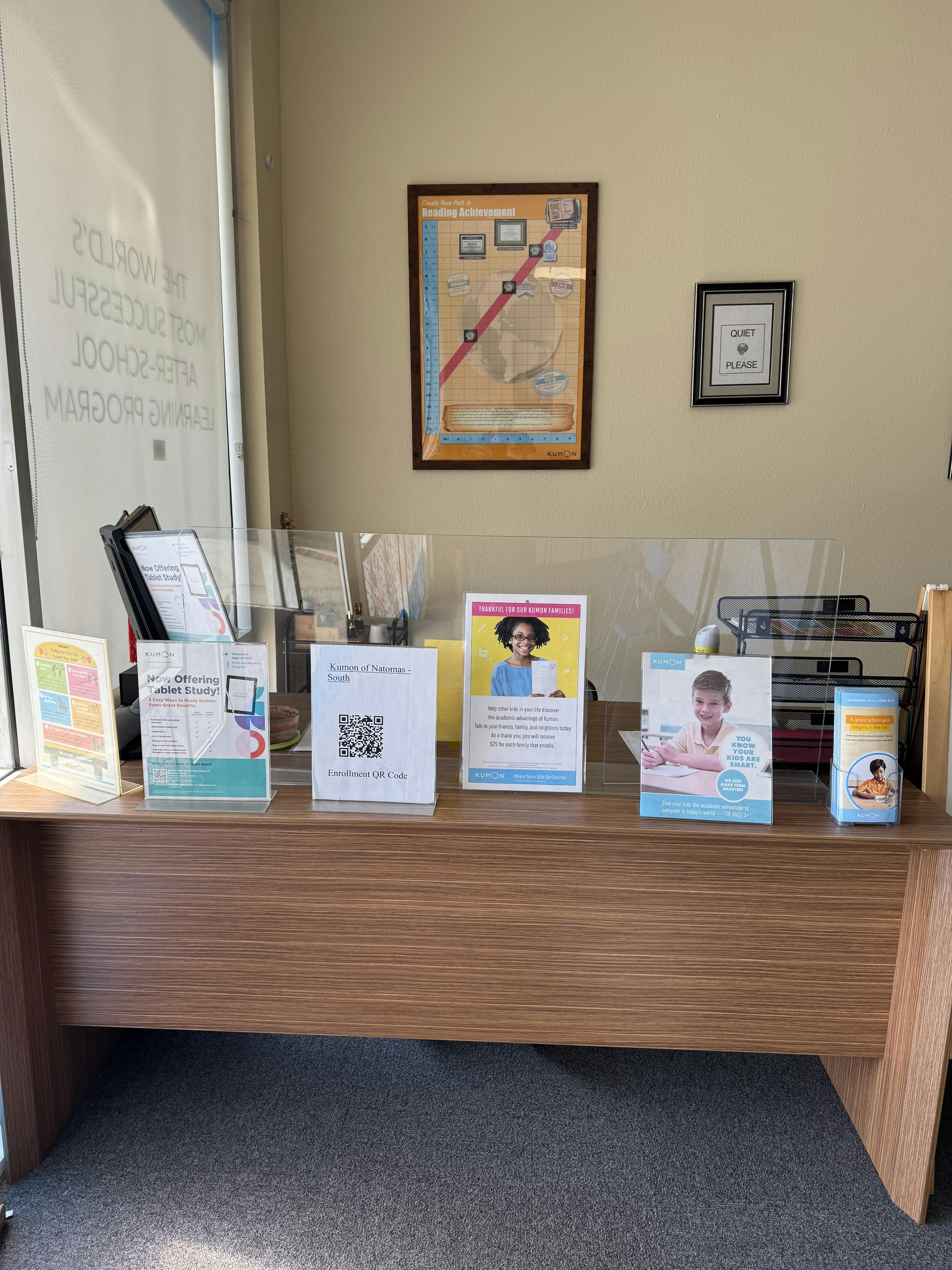 Reception desk with Kumon educational signs and a QR code sign