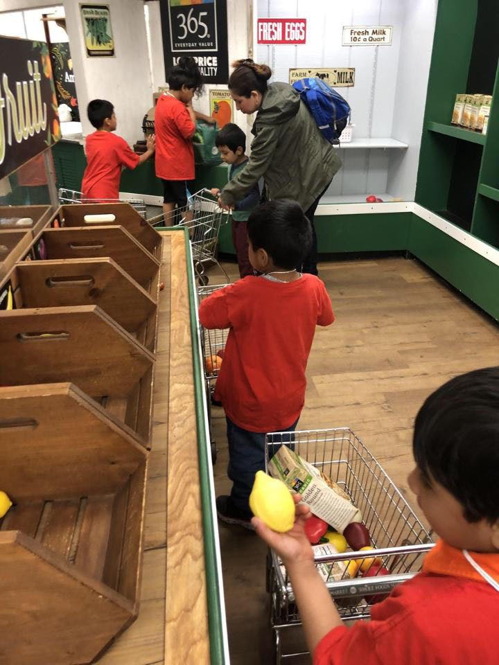 Adult and children shopping in a grocery store aisle