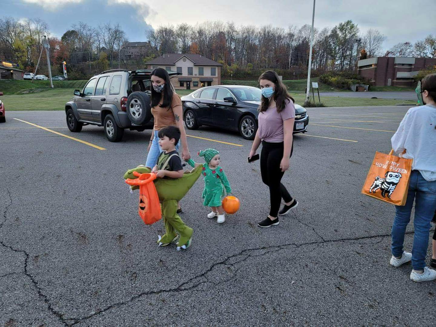 People and children in costumes walking in a parking lot