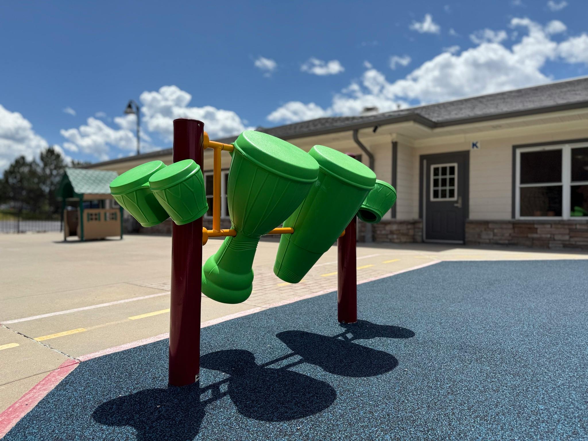 Green drum playground instrument on a blue surface