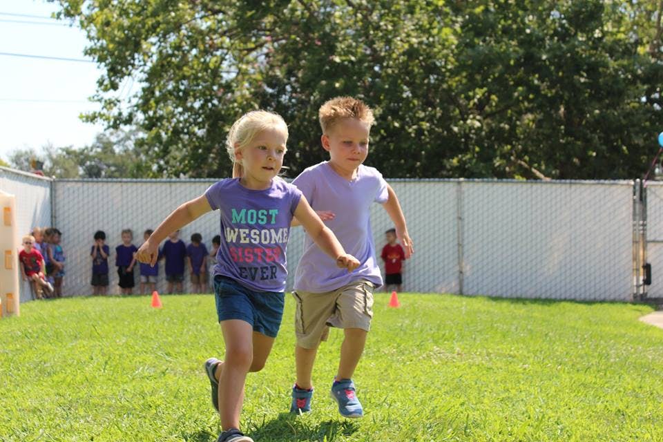 Two children running on grass