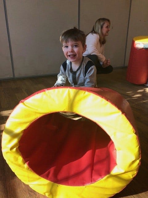 Child crawling out of a play tunnel