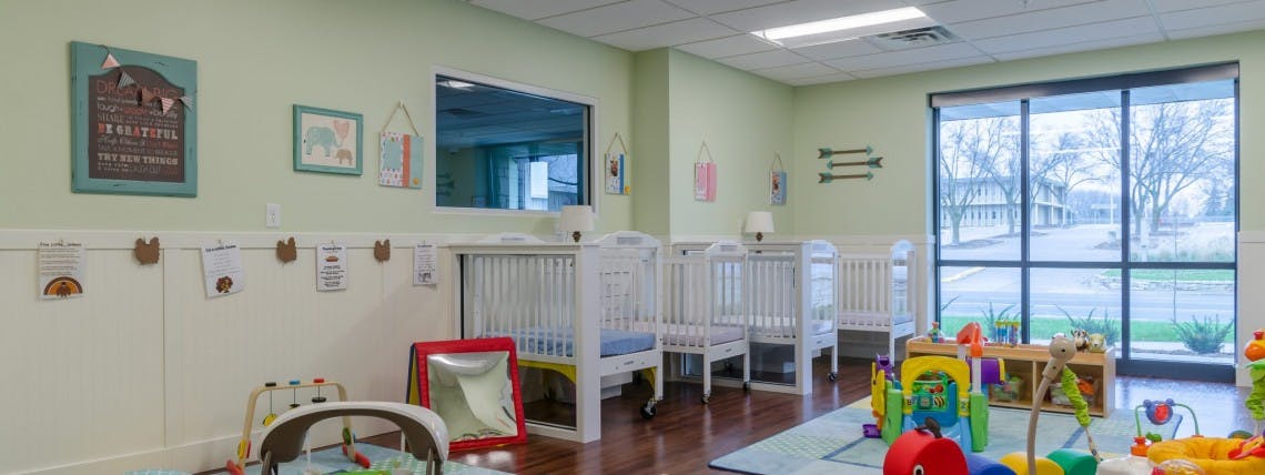 Nursery room with multiple cribs and toys