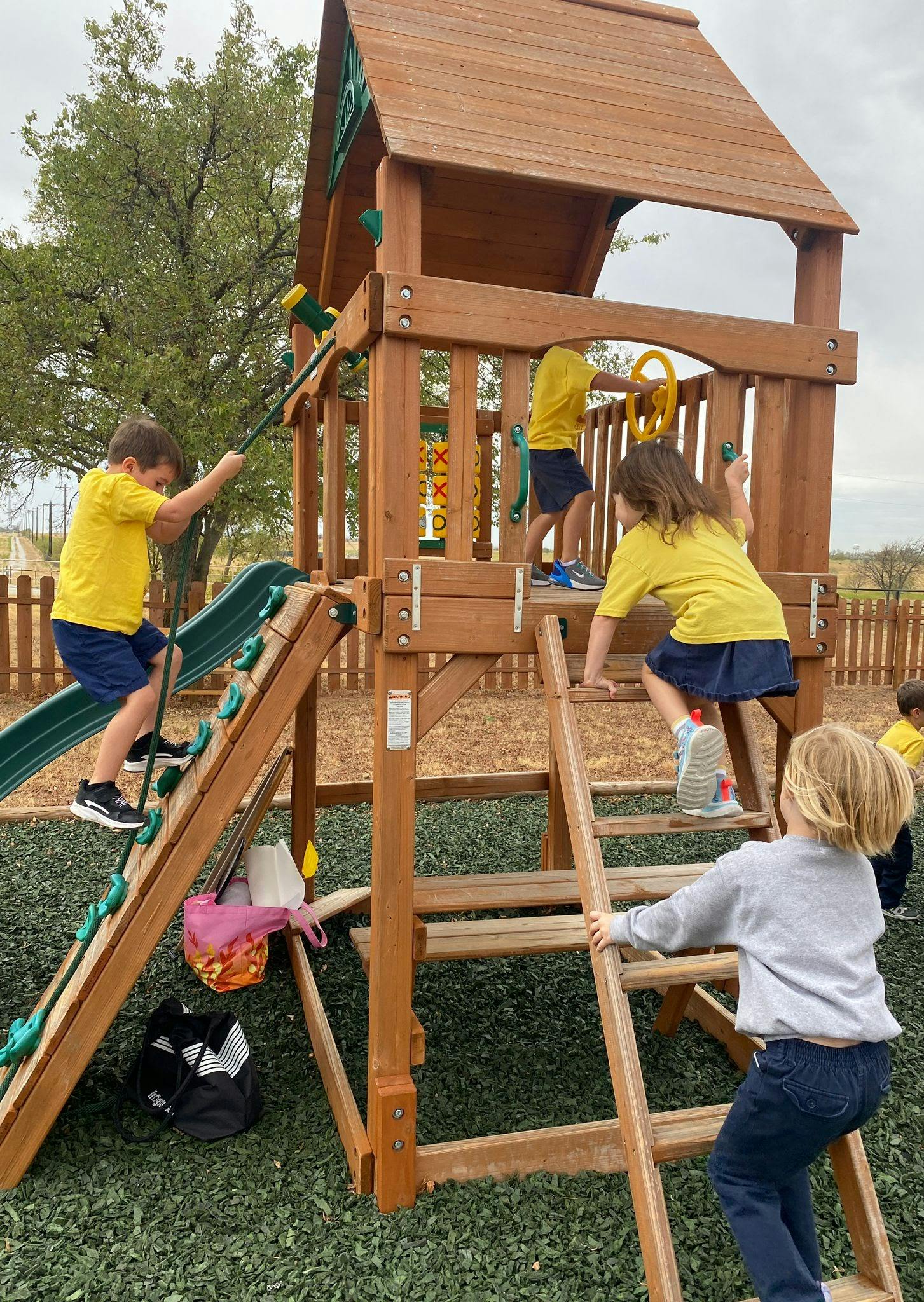 Children playing on a wooden playground structure