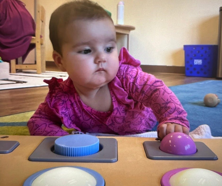 Child playing with a toy with colorful buttons