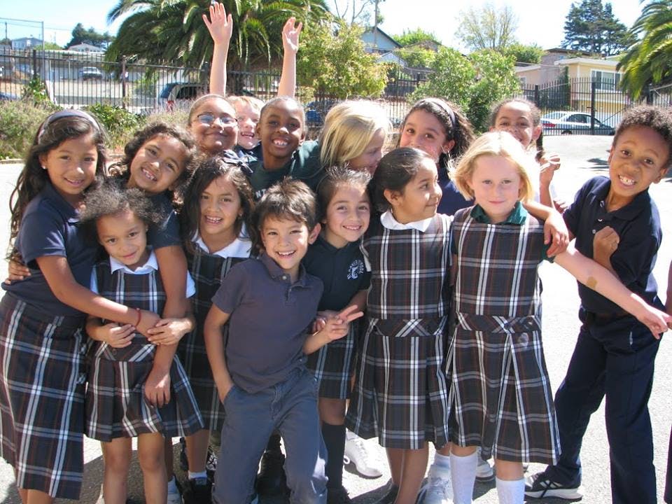 Group of children in school uniforms posing together outdoors