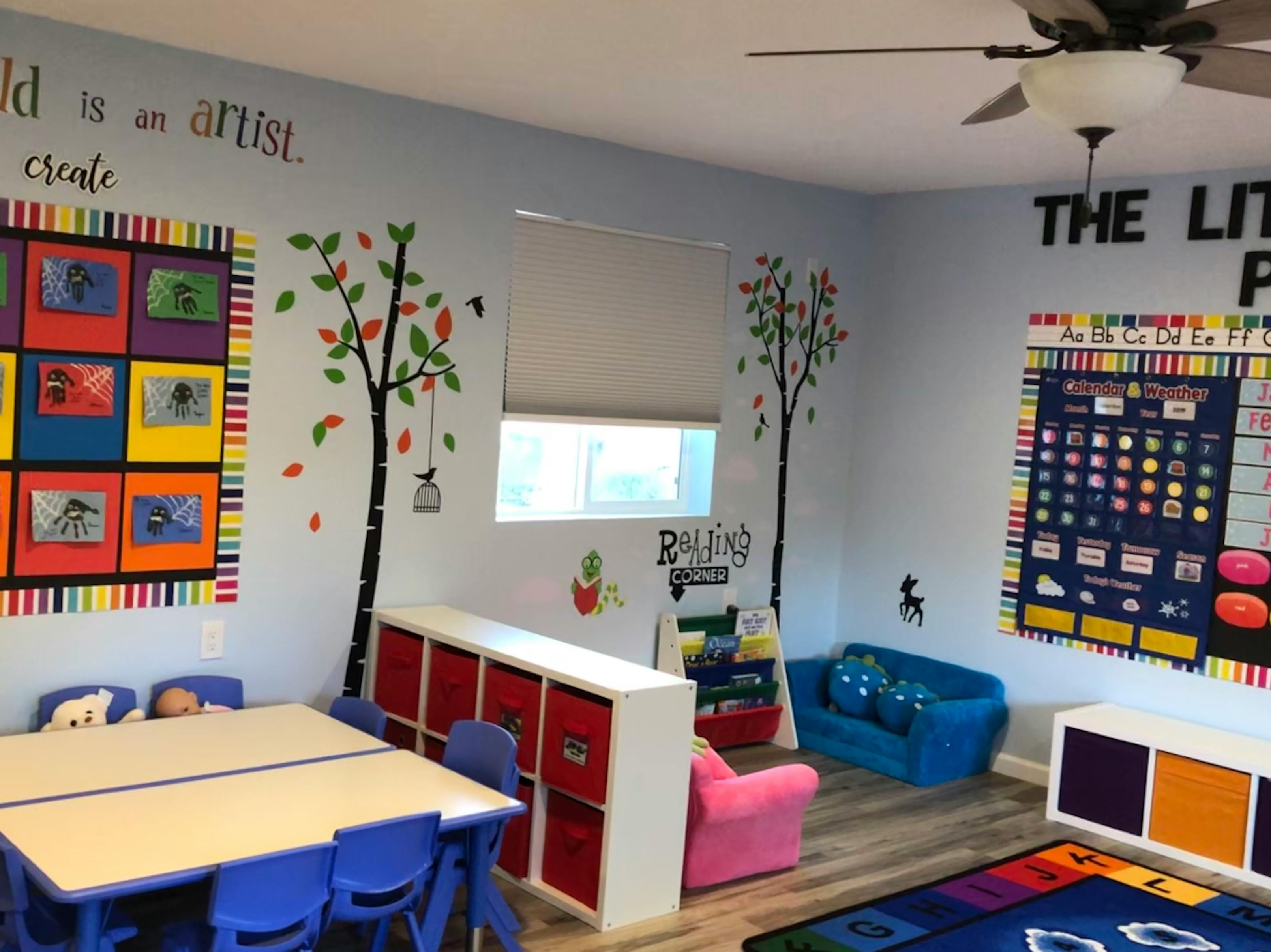 Classroom with small tables and chairs, storage units, and wall decorations
