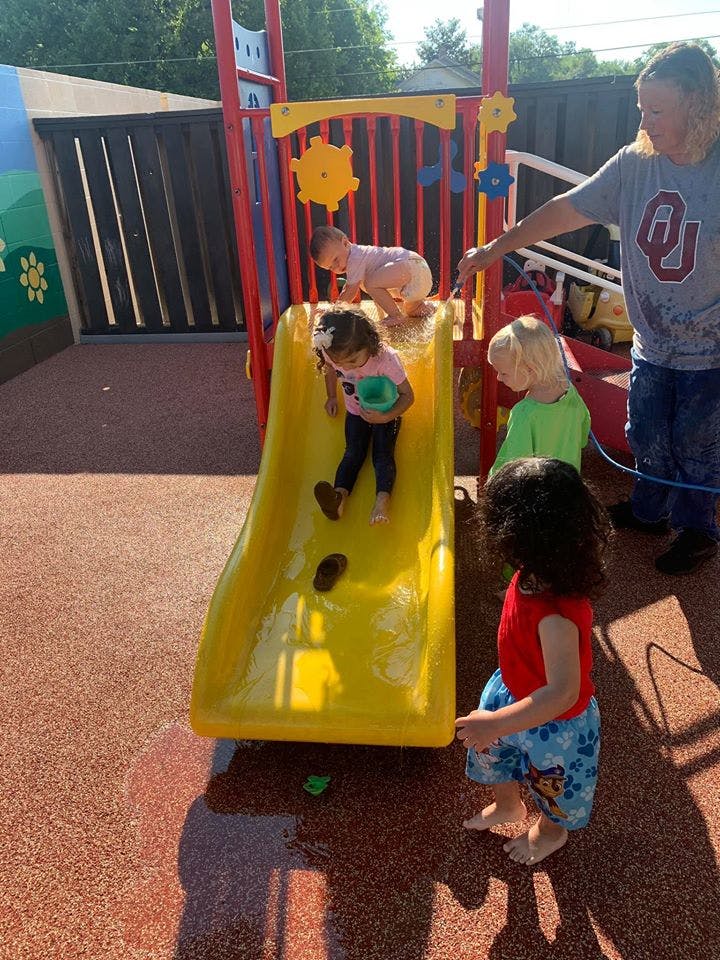 Children playing on a yellow slide at a playground