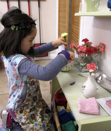 Child arranging flowers in a vase