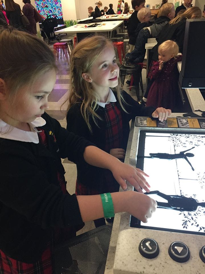 Two children interacting with an illuminated display