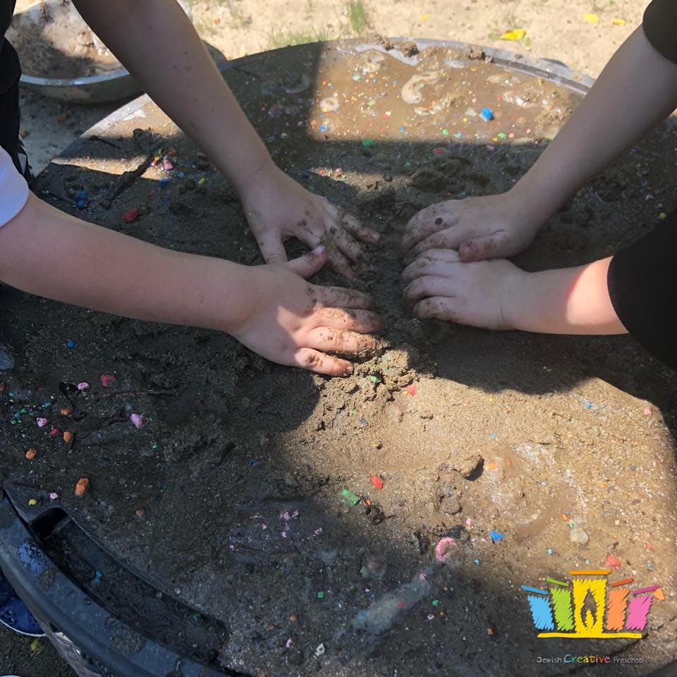 Children's hands playing in wet sand