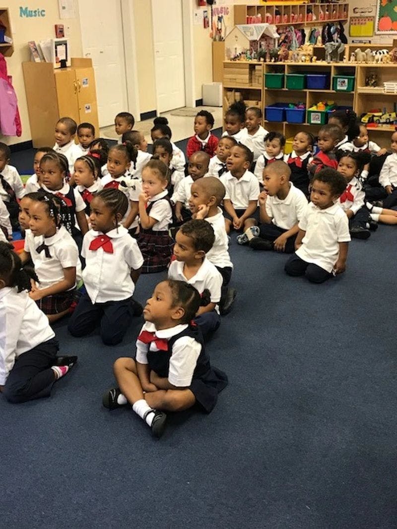 Group of children sitting on the floor in a classroom