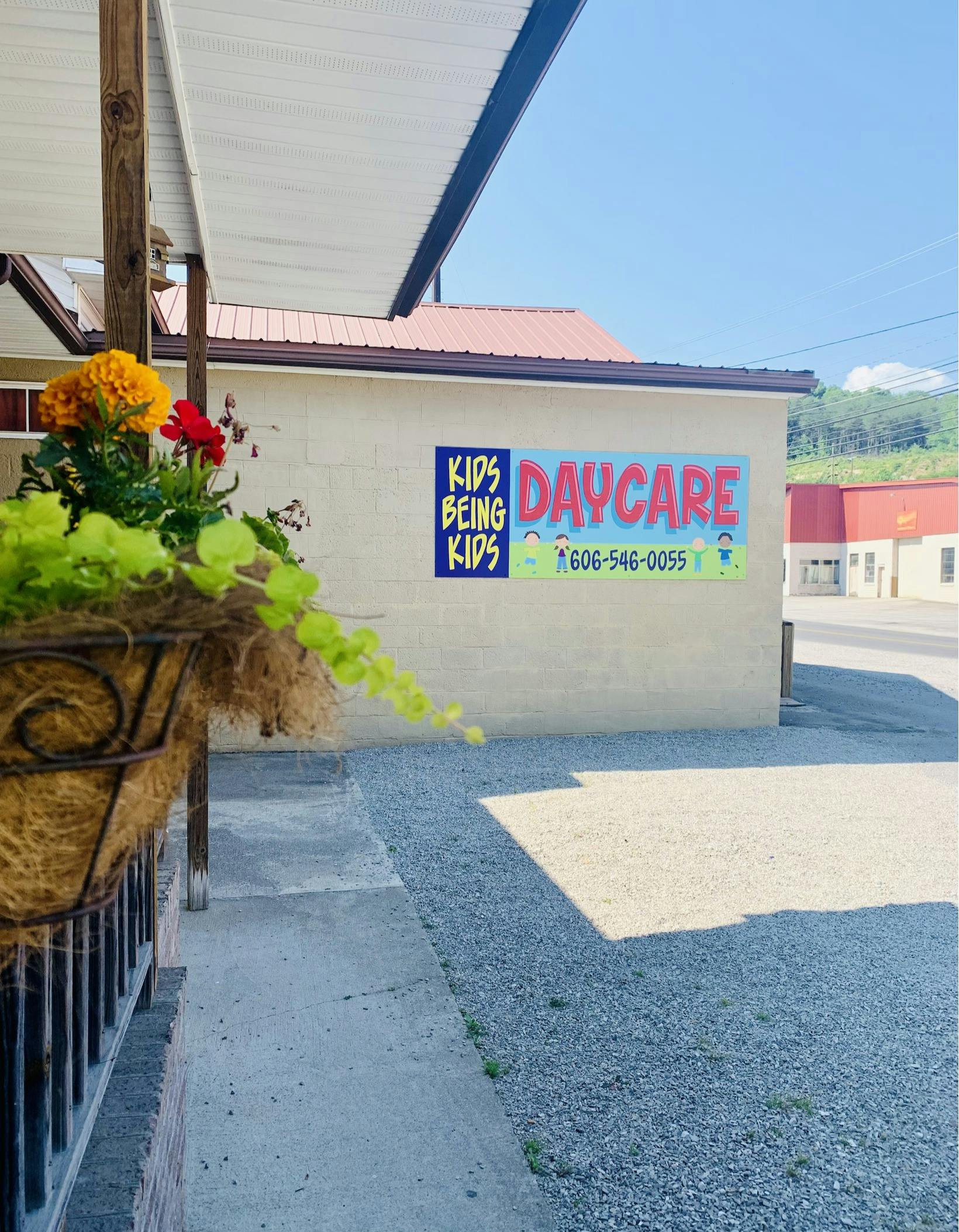 Daycare sign on a building with text "Kids Being Kids Daycare"